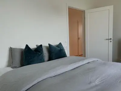 a bedroom with a bed with blue pillows at MJOS TOWER - Balcony Suite with lake view in Ringsaker