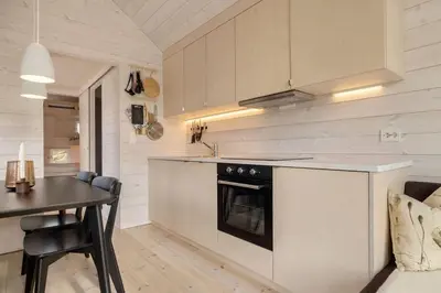 a kitchen with a table and a stove top oven at Tiny Mountain Cabin I in Stranda