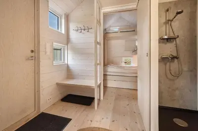 a small bathroom with a shower and a toilet at Tiny Mountain Cabin I in Stranda