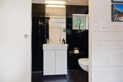 a bathroom with a white sink and a toilet at Tiny Mountain Cabin II in Stranda