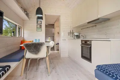 a small kitchen with a table and chairs in a tiny house at Tiny Mountain Cabin II in Stranda