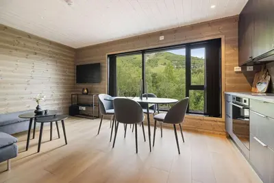 a kitchen and dining room with a table and chairs at Mountain View Apartment - 102 in Stranda