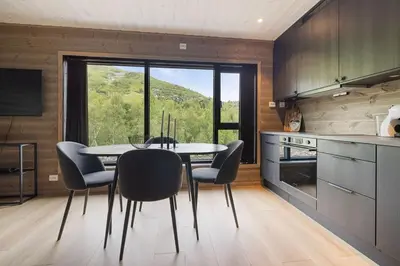 a dining room with a table and chairs in a kitchen at Mountain View Apartment - 102 in Stranda