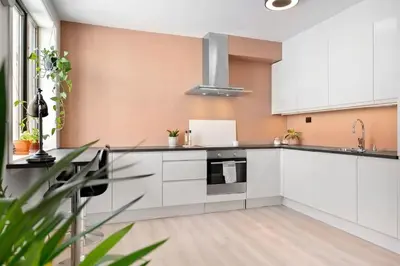 an empty kitchen with white cabinets and appliances at Sentral leilighet i Brosundet in Ålesund