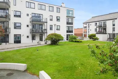 an empty lawn in front of a building at Sentral leilighet i Brosundet in Ålesund