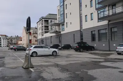 a parking lot with cars parked in front of buildings at Sentral leilighet i Brosundet in Ålesund