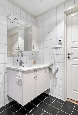 a white bathroom with a sink and a mirror at Sentral leilighet i Brosundet in Ålesund