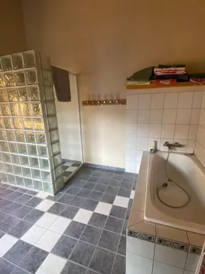 a bathroom with a tub and a tiled floor at Hus med plass til 7 personer til leie in Veka