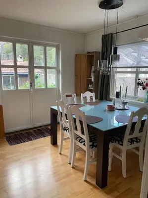 a dining room with a blue table and white chairs at Hus med plass til 7 personer til leie in Veka