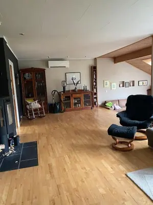 a large living room with wooden floors and furniture at Hus med plass til 7 personer til leie in Veka