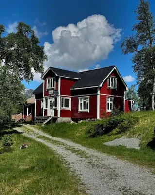 a red house on a hill with a dirt road at Handeland Lodge Near Trolltunga and Pulpit Rock Sleeps 18 with Sauna in Sauda