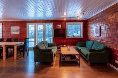 a living room with two couches and a table at Handeland Lodge Near Trolltunga and Pulpit Rock Sleeps 18 with Sauna in Sauda