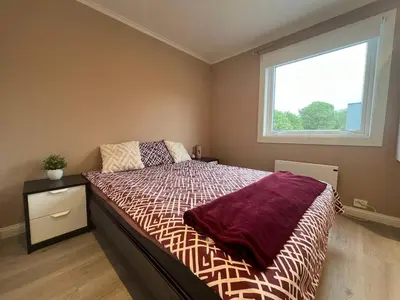 a bedroom with a large bed with a window at Sunny gateaway Room in Lerstad, Suitable for two guests in Ålesund