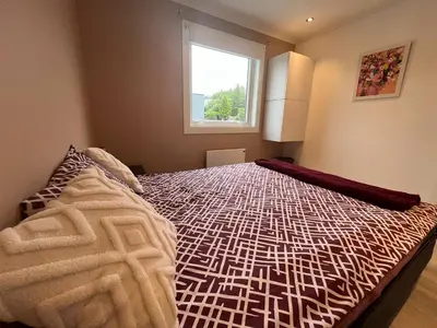 a bedroom with a bed with a comforter and a window at Sunny gateaway Room in Lerstad, Suitable for two guests in Ålesund