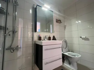 a bathroom with a sink and a toilet and a shower at Sunny gateaway Room in Lerstad, Suitable for two guests in Ålesund