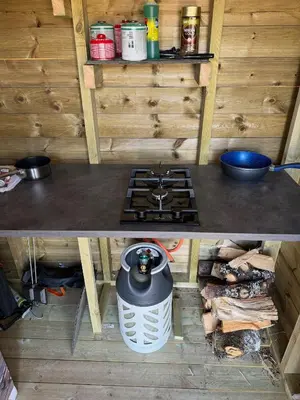 two pictures of a kitchen with a stove in a cabin at Handeland Lodge I Arctic Dome in Sauda