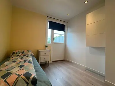 a bedroom with a bed and a window at Cozy Urban Single Room in Ålesund