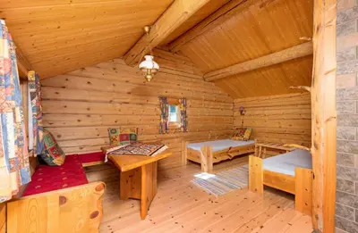 a log cabin with benches and tables in a room at Skogcamping in Bjørnstad