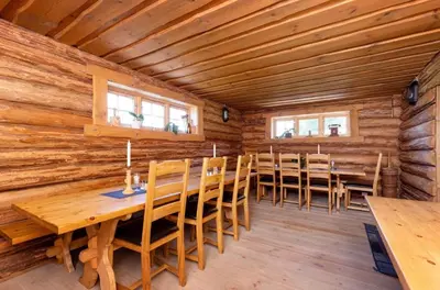 a dining room with a long wooden table and chairs at Skogcamping in Bjørnstad