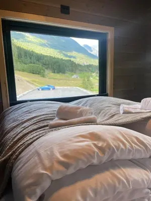 a bed in a room with a large window at Stryn Golden Resort - Panorama I in Stryn