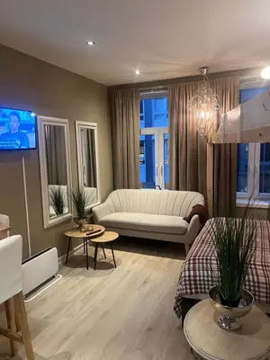 a living room with a couch and a tv at Ålesund sentrum Parkgata in Ålesund