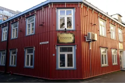 a red building with a sign on the side of it at Corner apartment with 2 bedrooms in the middle of the city centre in Trondheim