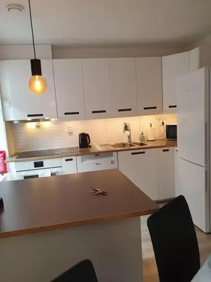 a kitchen with white cabinets and a wooden counter top at Corner apartment with 2 bedrooms in the middle of the city centre in Trondheim
