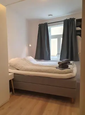 a bed in a room with a window at Corner apartment with 2 bedrooms in the middle of the city centre in Trondheim