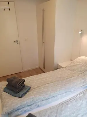a bedroom with a bed with two towels on it at Corner apartment with 2 bedrooms in the middle of the city centre in Trondheim