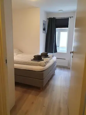 a small bedroom with a bed and a window at Corner apartment with 2 bedrooms in the middle of the city centre in Trondheim