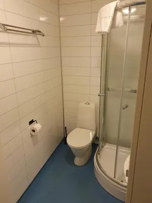 a bathroom with a toilet and a glass shower at Corner apartment with 2 bedrooms in the middle of the city centre in Trondheim
