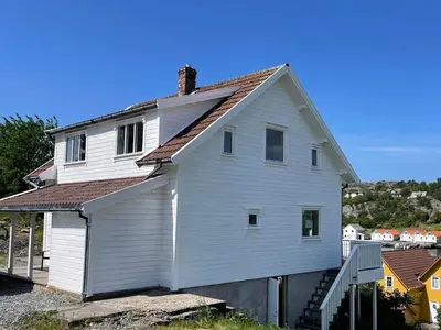a white house with a brown roof at 6 person holiday home in BØMLO in Bømlo