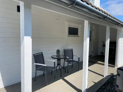a patio with chairs and a table on a deck at 6 person holiday home in BØMLO in Bømlo