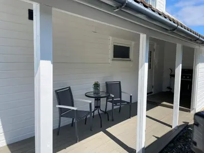 a patio with chairs and a table on a deck at 6 person holiday home in BØMLO in Bømlo