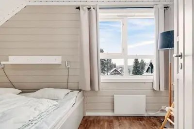 a bedroom with a bed and a window at Hytte med sentral beliggenhet in Trysil