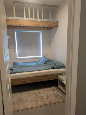 a bedroom with a bunk bed with a window at Liten leilighet midt i sentrum in Stryn
