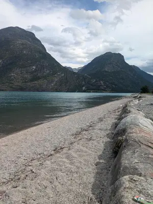 a rocky beach next to a body of water at Liten leilighet midt i sentrum in Stryn