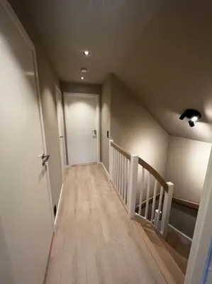 a hallway with a staircase with a white door and a stairwayngthngthngth at Nytt hus i fredfullt nabolag in Verdal