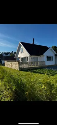a white house with a fence in a field at Nytt hus i fredfullt nabolag in Verdal