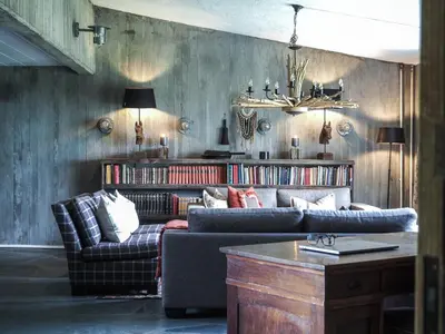 a living room with two couches and a book shelf at Danebu Kongsgaard - Boutique Hotel in Aurdal