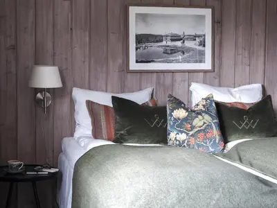 a bedroom with a bed with pillows on it at Danebu Kongsgaard - Boutique Hotel in Aurdal