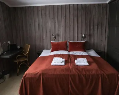 a bedroom with a large bed with two towels on it at Danebu Kongsgaard - Boutique Hotel in Aurdal