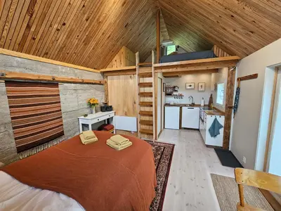 a room with a bed and a kitchen in it at Sigurd's Tiny House in Vossevangen