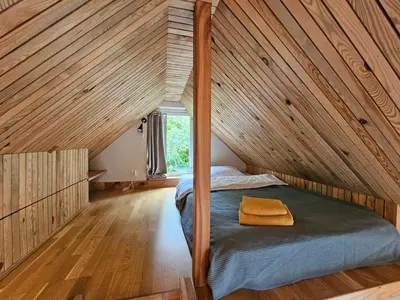 a bed in a room with a wooden ceiling at Sigurd's Tiny House in Vossevangen