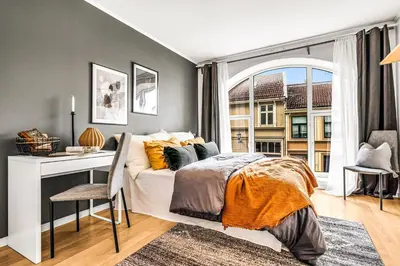a bedroom with a bed and a desk and a window at 3-Bedroom - Heart of Trondheim Center in Trondheim