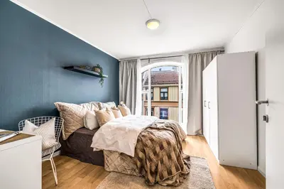 a bedroom with a bed and a blue wall at 3-Bedroom - Heart of Trondheim Center in Trondheim