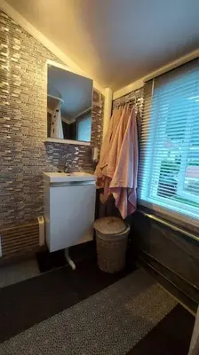 a bathroom with a sink and a mirror and a window at Old Town House in Rjukan