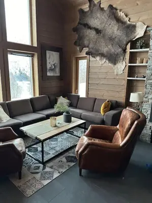 a living room with a couch and chairs and a table at Myrkdalen Lodge II, luxury family cabin ski in and out in Helgatun