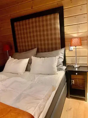 a bed with white sheets and pillows in a room at Myrkdalen Lodge II, luxury family cabin ski in and out in Helgatun