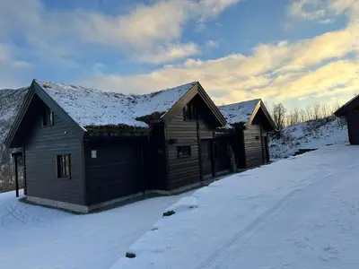 a wooden house with snow on the roof at Myrkdalen Lodge II, luxury family cabin ski in and out in Helgatun